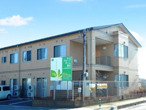 「愛の家グループホーム 越谷」の外観。敷地内に駐車場がある。