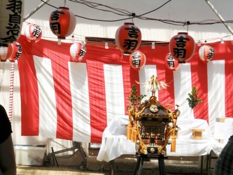 紅白幕と提灯の飾られたお祭り会場に奉納されているお神輿