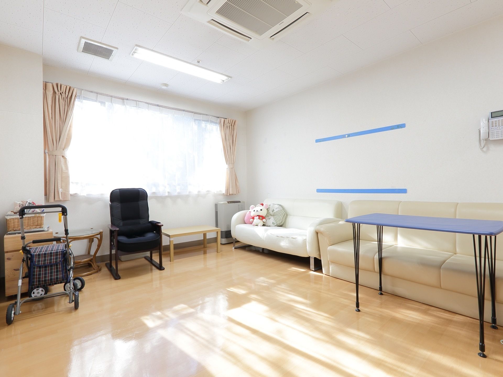 リビングにソファやテーブルが置かれている。大きな窓からは自然光が入り、明るい雰囲気を醸し出している。