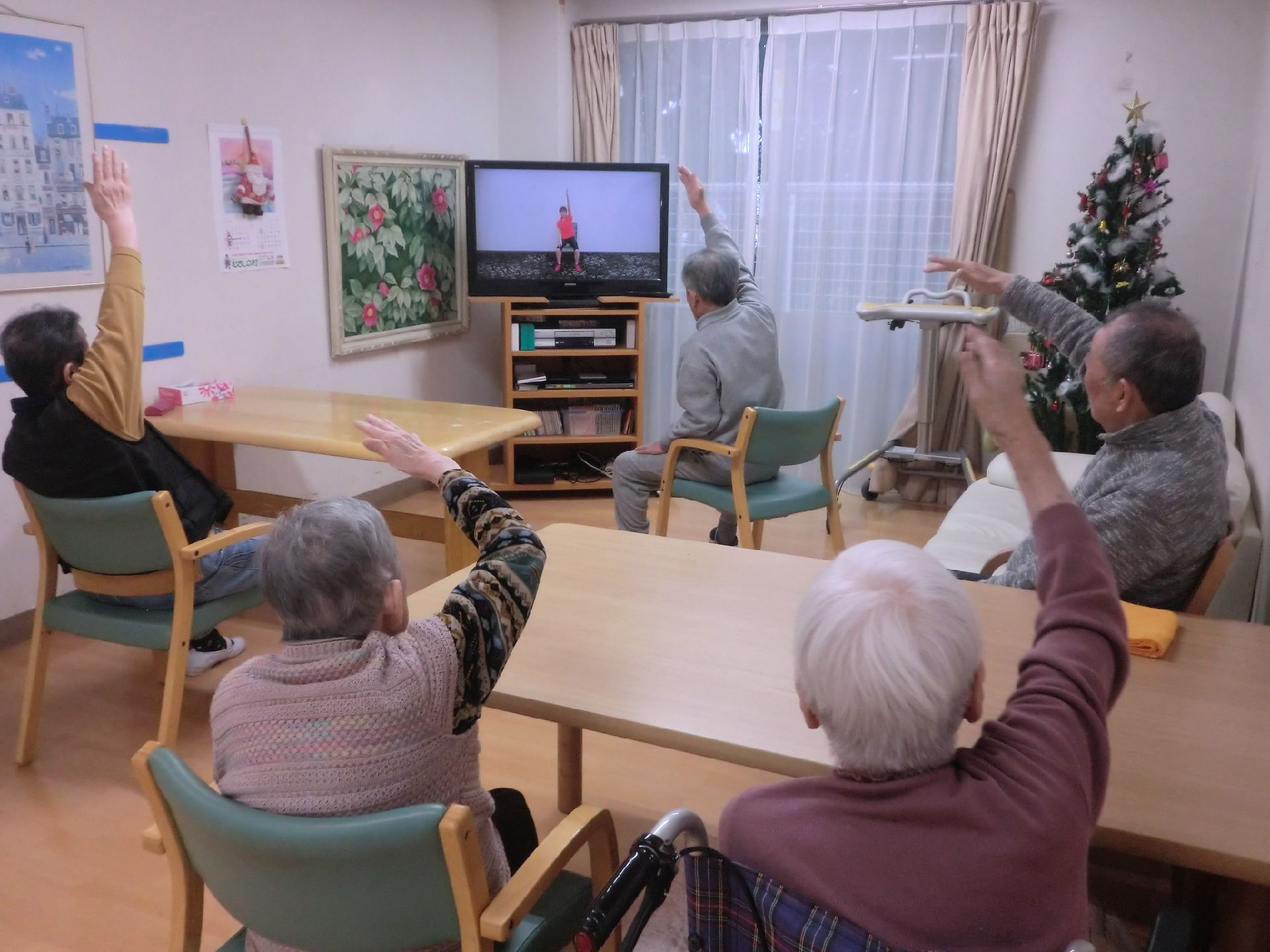 車椅子に乗ったシニア2人とそれに続いて建物から出てきた4人