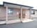 屋根は紺色で壁はレンガ調に作られている。風合いのある横長の１階建てで、大きめのひさしがあり、玄関先にはスロープや手すりも設置されている。
