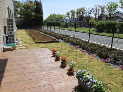 広々とした中庭にはプランターの花が飾られており、芝生や花壇も設置されている。周囲にも緑が多くあり、リラックスできる場所である。