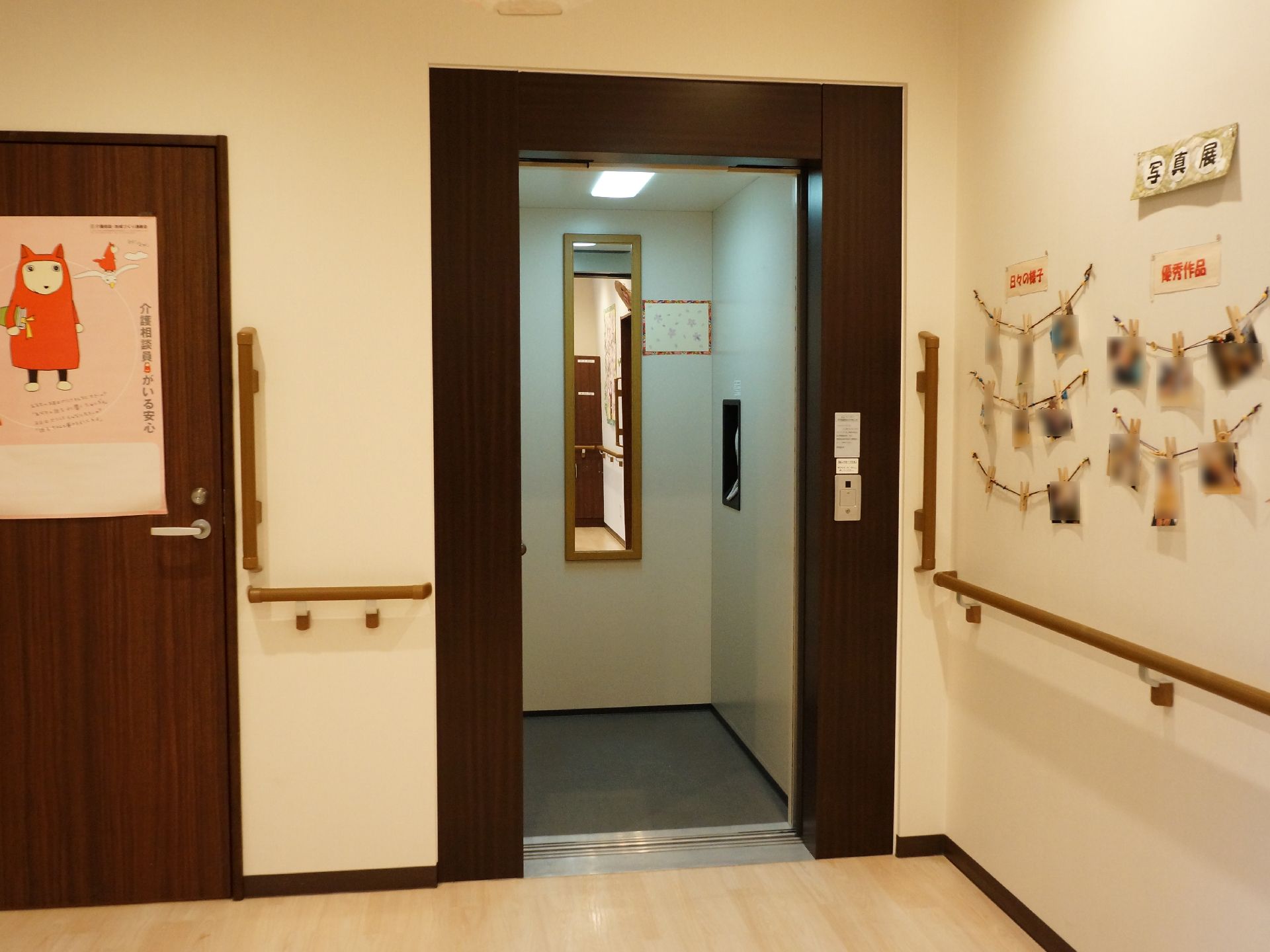 施設内はエレベーターで上下の階に快適に移動して頂ける。手すりが付いているので伝い歩きができる。壁には写真が貼られている。