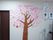 ドアの隣の壁に紙で作られた木、そこに花を咲かせる桜が飾られている。隣には住居者様が書いた習字が貼られ、前にはテレビと掃除機がある。