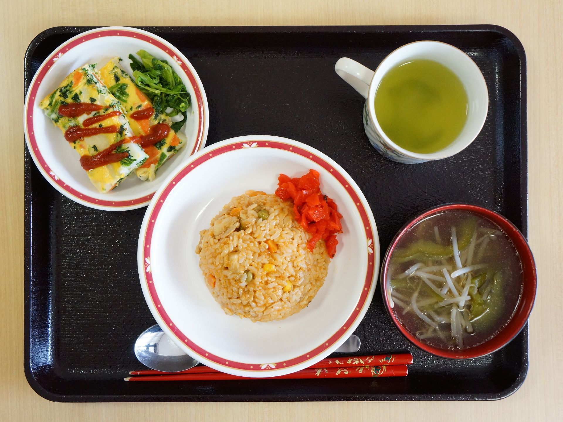 食事は一人ずつ黒いお盆の上に配膳される。この日のメニューは炒飯で、他にも卵のおかずや汁物、お茶もついている。