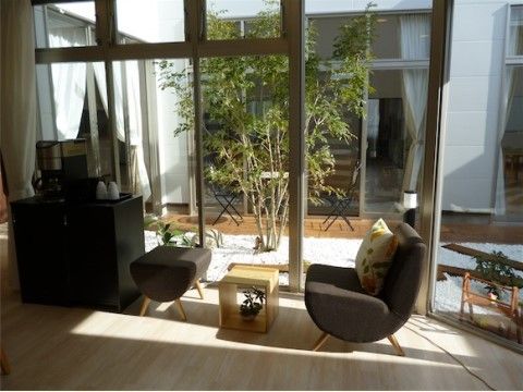 吹き抜けの中庭に植えられた植物を眺められる一人掛けソファ