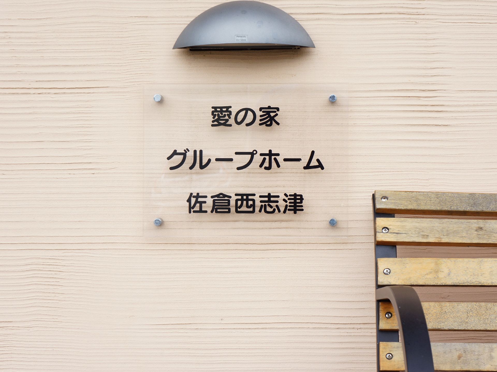 シンプルな表札。夜になり、照明が灯るとアクリルプレートに光が当たってライトアップされ、おしゃれな雰囲気。