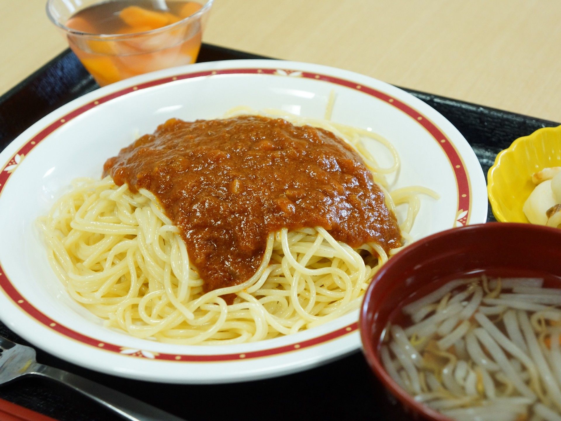 パスタとフルーツポンチ、もやしのスープがお盆に乗った昼食。