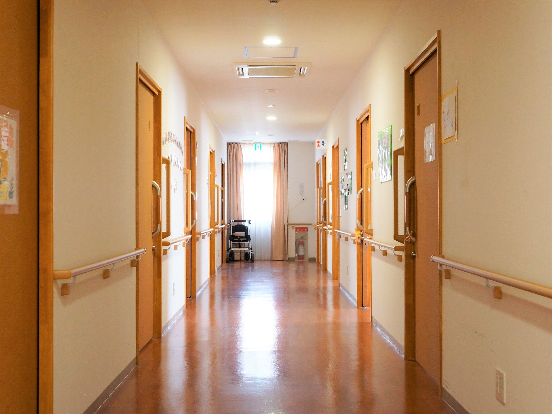 手すりも常設してある幅広の廊下の両側に、トイレを含めた10の扉がある。廊下突き当りの窓は非常口の表示がある。車椅子も用意してある。