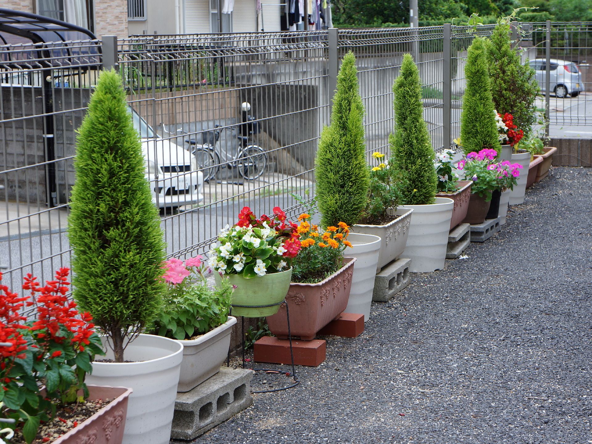 施設の周囲には観葉植物や色とりどりの花が咲くプランターが置かれている。地面には砕石が敷かれ、綺麗に整えられている。