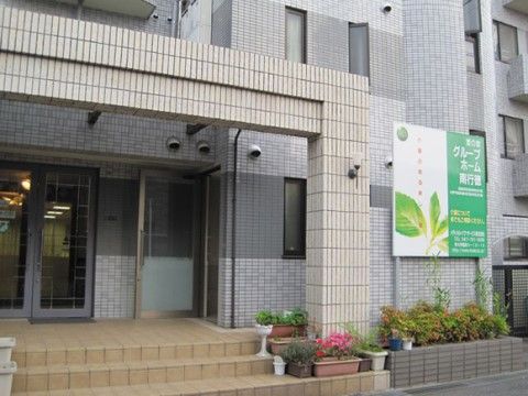 入り口に複数のプランターに植えられた植物を飾っているビル