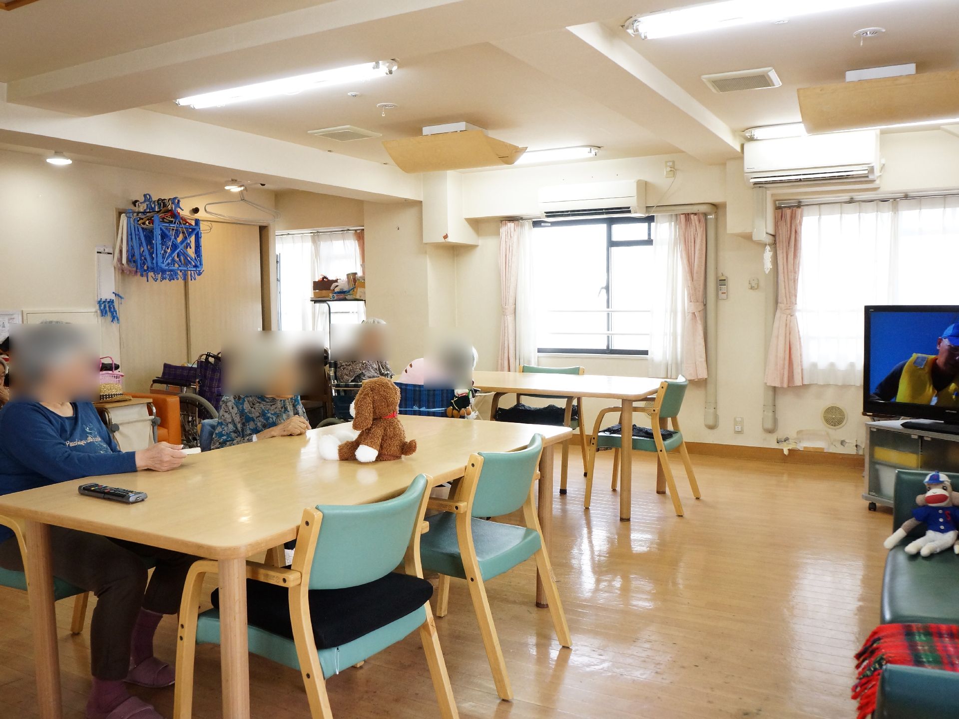 スプーンで食事を口に運ぶペイズリー柄のシャツを着た入居者
