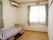 エアコンの設置されたうローリングの部屋には窓が2面にありカーテンがかかっている。また電動の介護用ベッドが置かれている。
