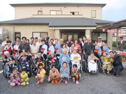 小さな子供を交えて和服で記念撮影を行っている入居者たち