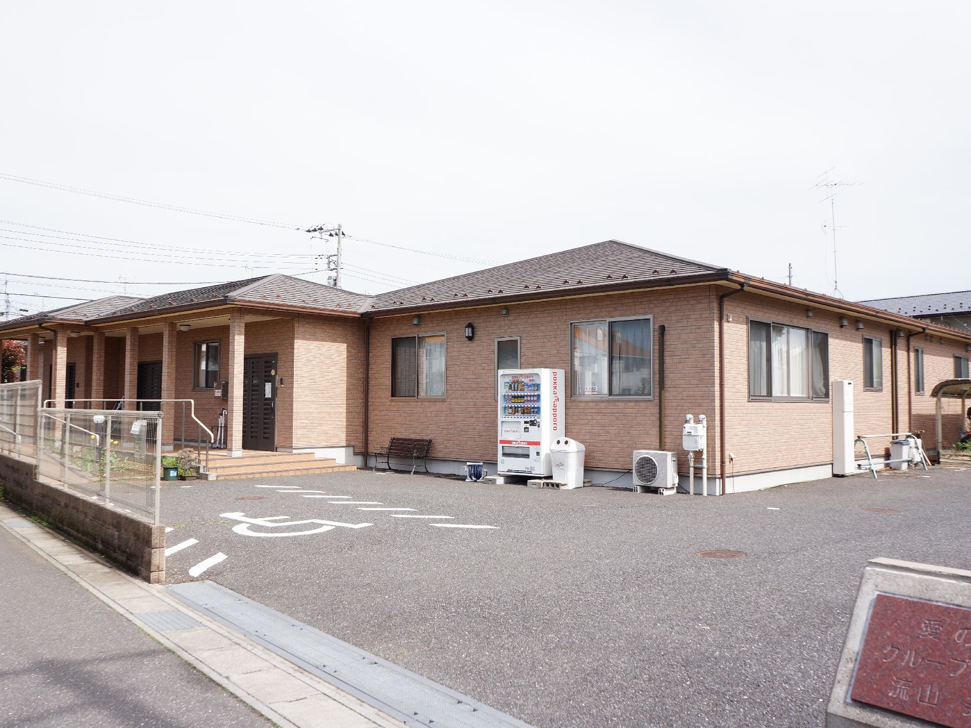 施設は人通りの少ない通りに面しており、レンガ風タイルの外観で1階建ての広い作りの縦もである。優先駐車スペースがある。