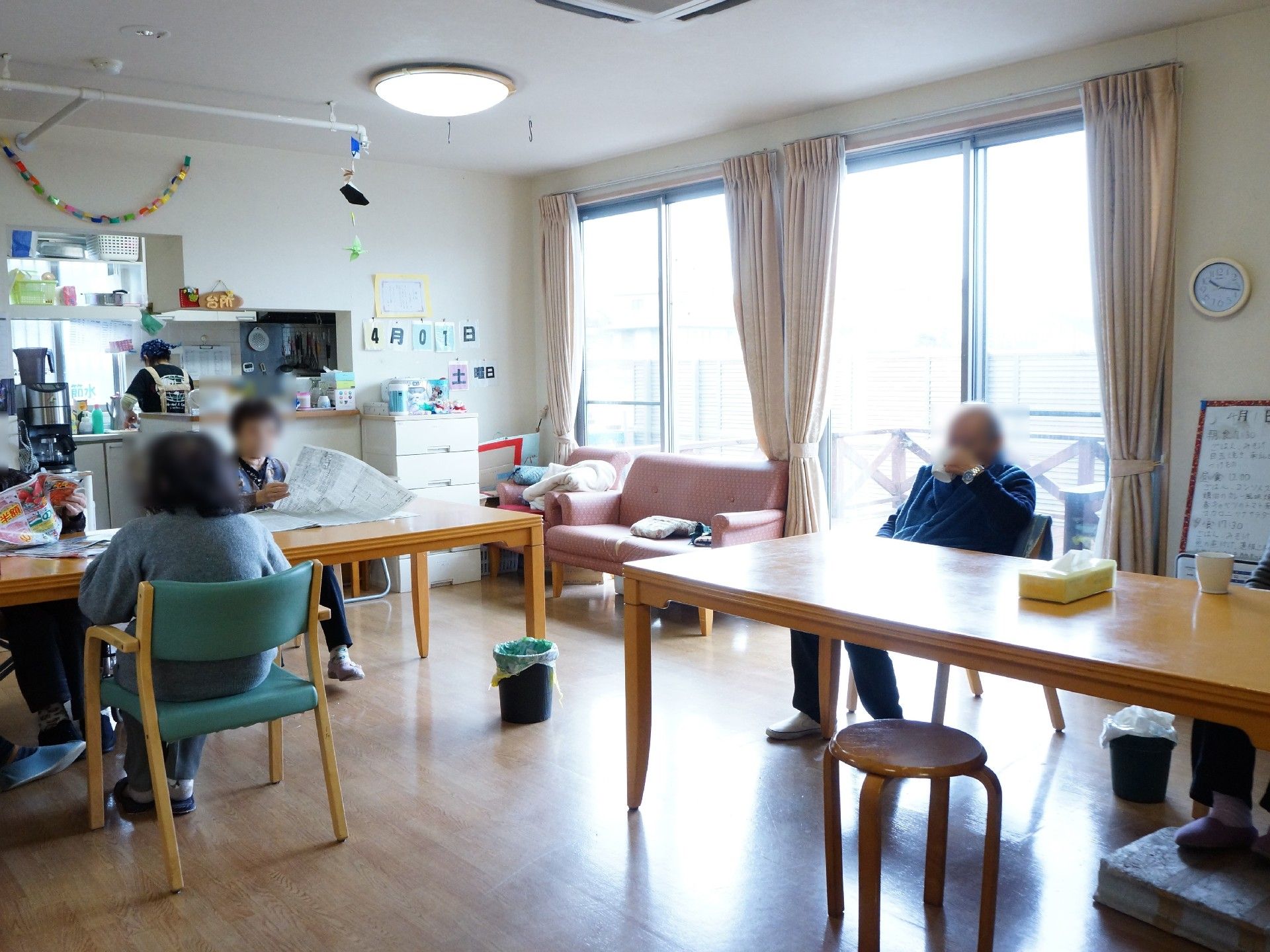 大きな窓から光が差し込む共用スペースでは、居住者がテーブルで新聞を読んだりソファに座ったりと、思い思いに過ごすことができる。