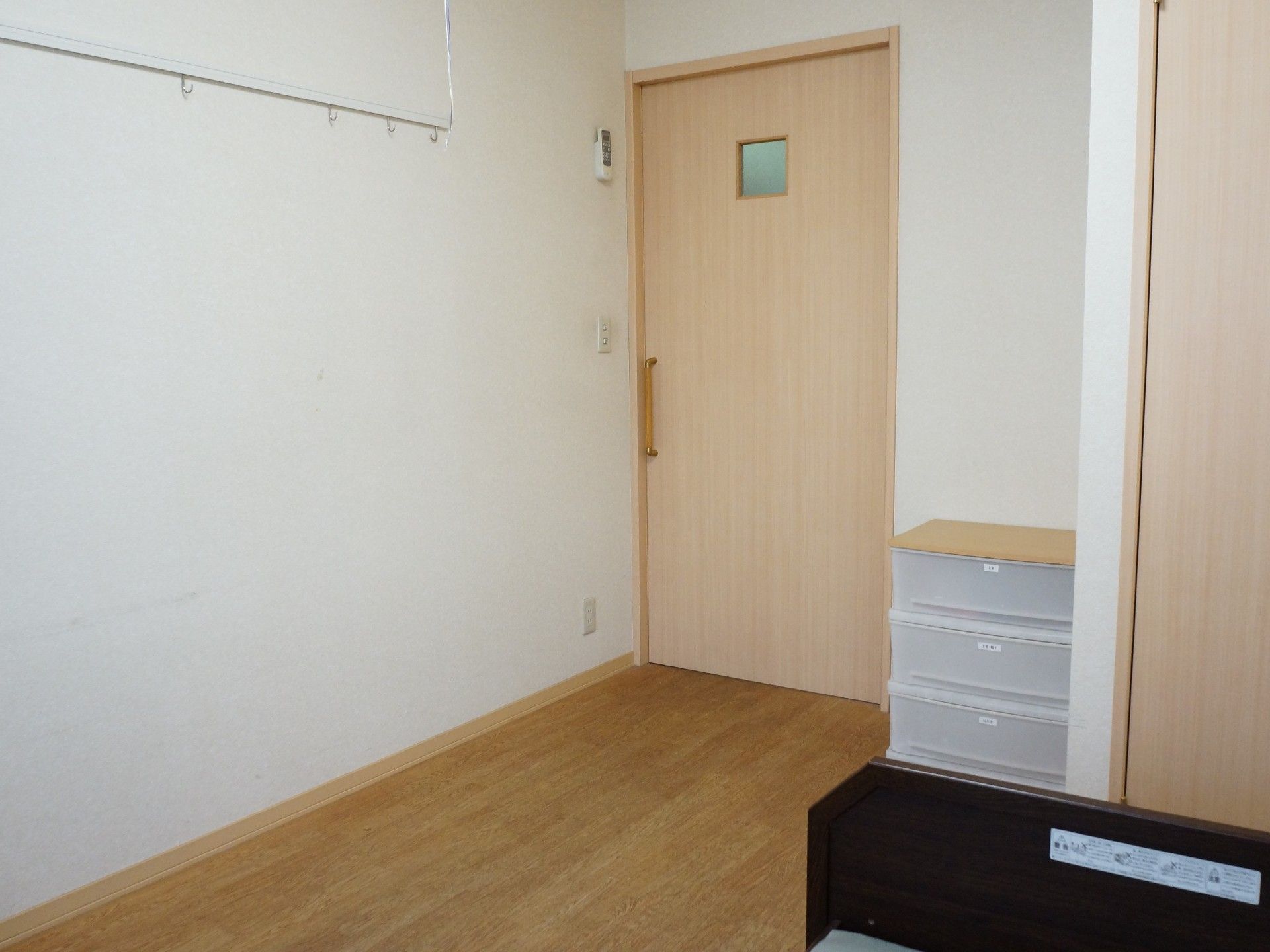 居室のドアを開ける扉は、開けやすい手すり式になっている。壁にはフックも取り付けられているので、カレンダー等をかけることができる。