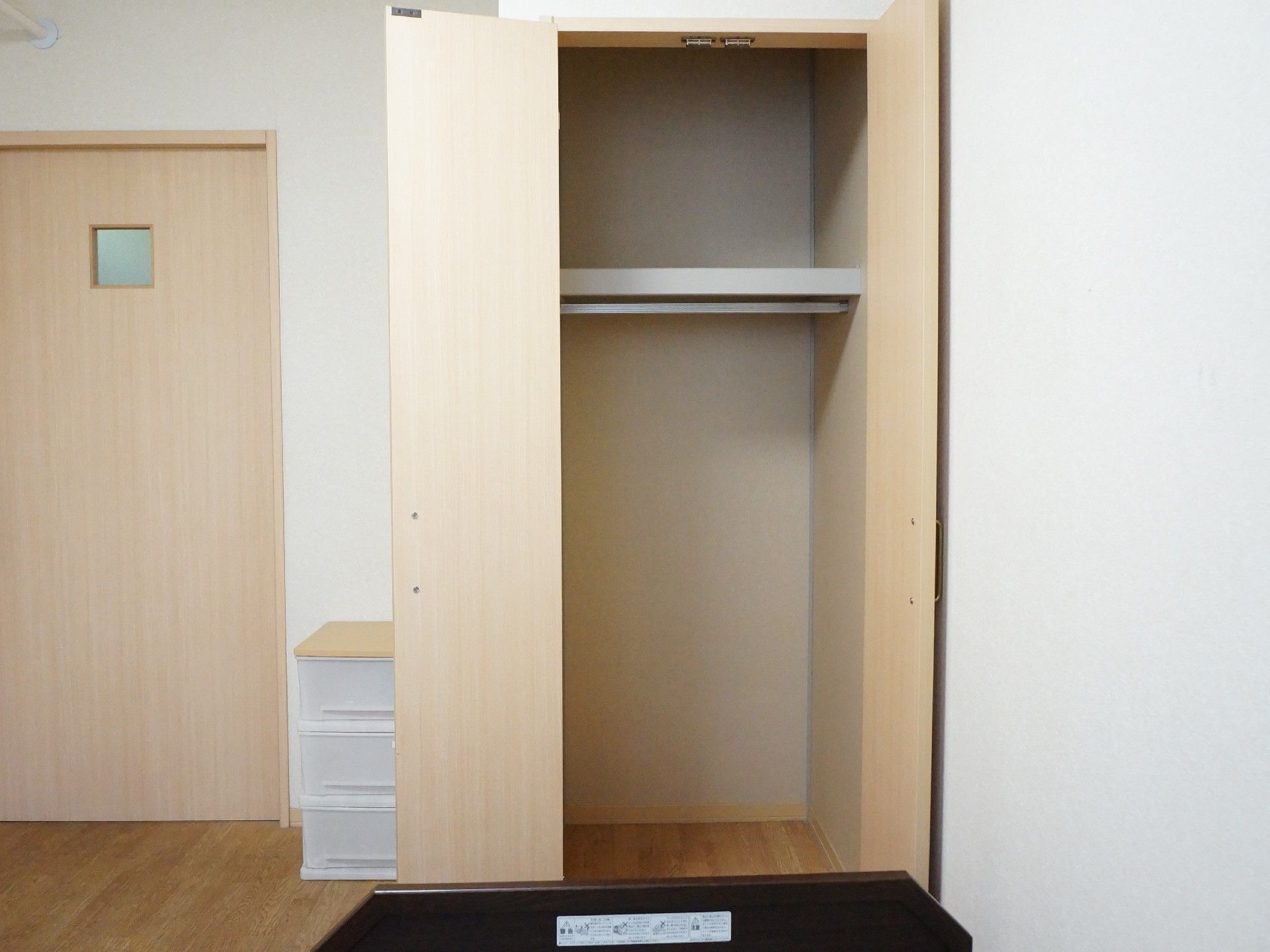居室にはウォークインクローゼットがあります。衣類をハンガーに吊り下げて収納することができ、上段にも収納スペースがある。