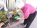 入居者様が鉢植えの植物の手入れをしている。建物内から見ることができ、その成長を日々見守ることができる。