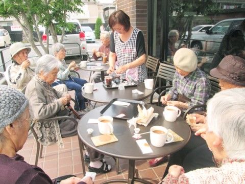 ガーデンチェアに座って、お茶やおやつを楽しんでいる入居者様