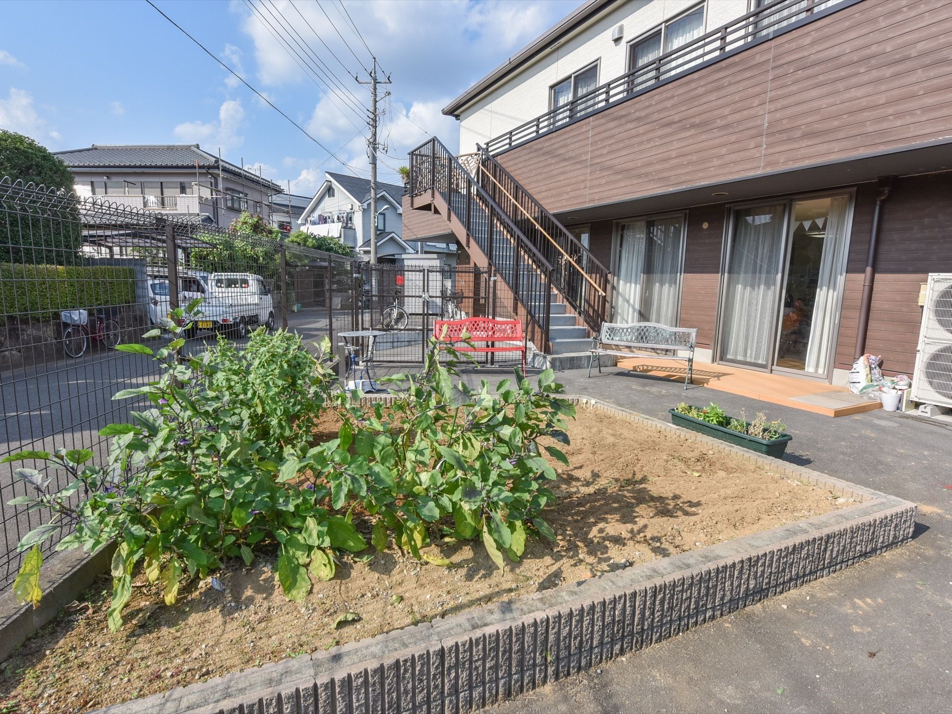 敷地内には菜園があり、周囲にはテーブルや椅子がある。２階のベランダへは階段にて、自由に昇り降りができるように手すりも取り付けられている。