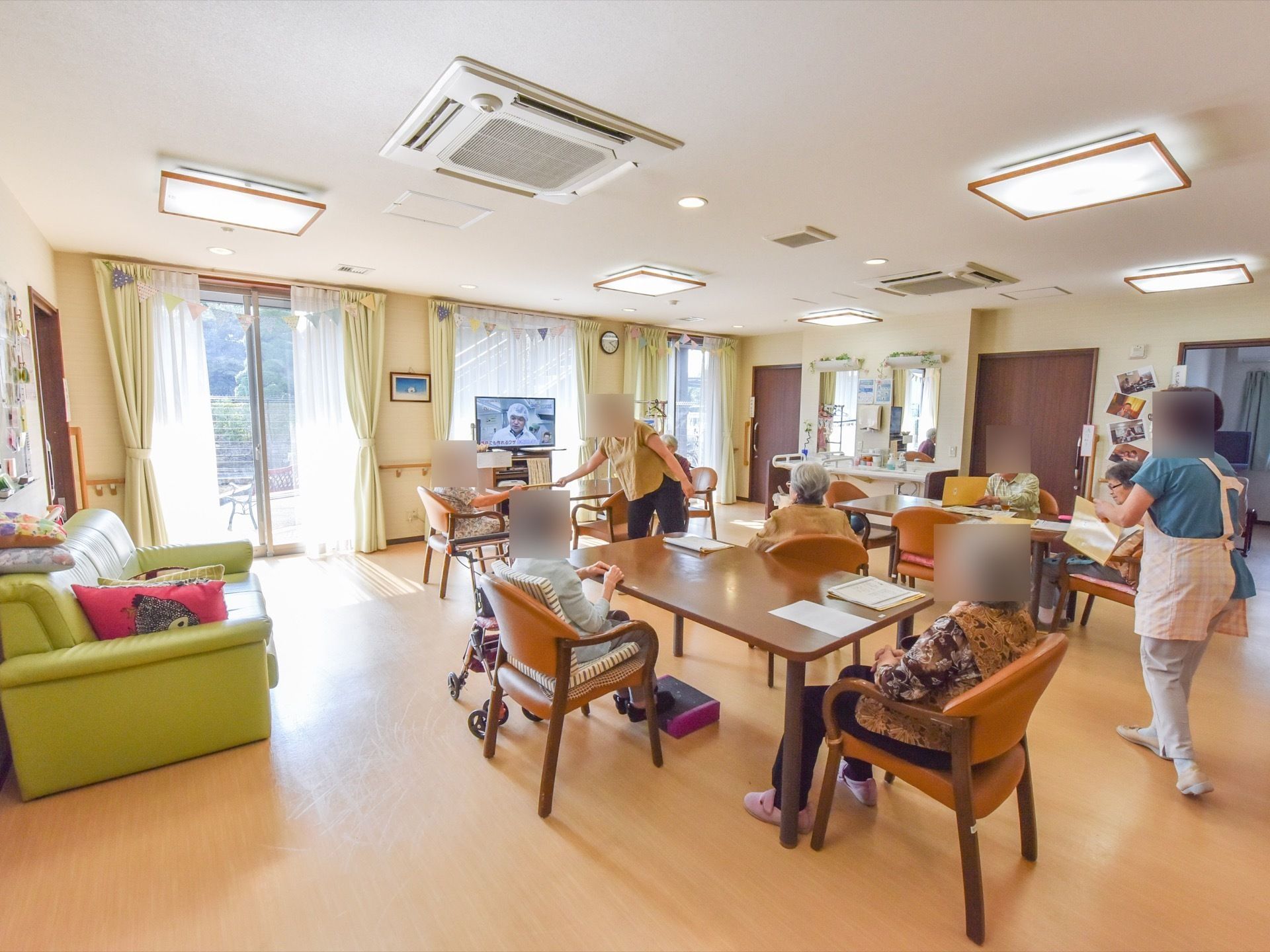 日当たりのよい明るい談話室である。大型液晶テレビや4人掛けのダイニングテーブル、ゆったり座れるソファが完備されている。