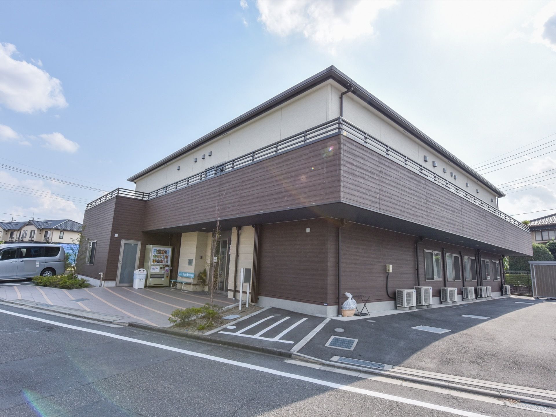 ２階建てのモダンな建物である。エントランス一帯はバリアフリー構造でベンチや自動販売機がある。駐車場は目の前で便利である。