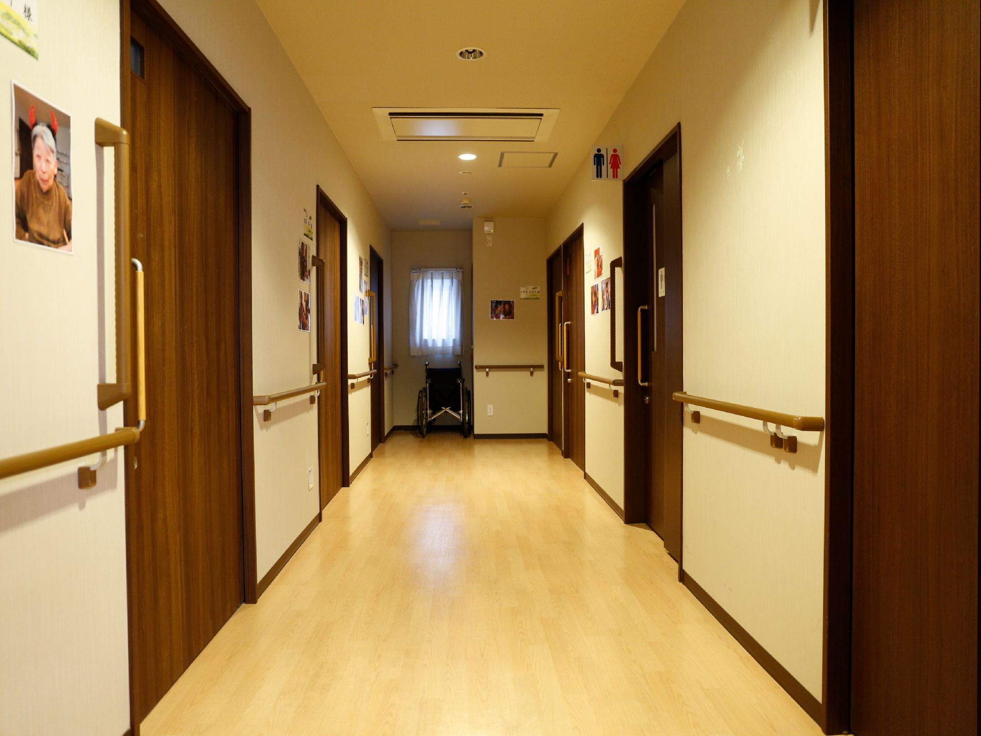 廊下には手すりが取り付けられている。トイレのドアの前には、標識があるため分かりやすい。窓の前には車椅子が置かれている。