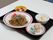 ある日の食事メニュー。焼きそば、鮭とわかめのおにぎり、ポテトサラダが食事メニューであり、デザートにはイチゴが出る。