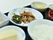 お膳に本日の食事がのっている。豚肉とほうれん草などの炒め物、ご飯、お吸い物、卵豆腐、バナナなどである。