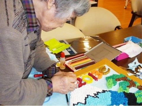 テーブルの傍に立って創作活動を楽しんでいる入居者様