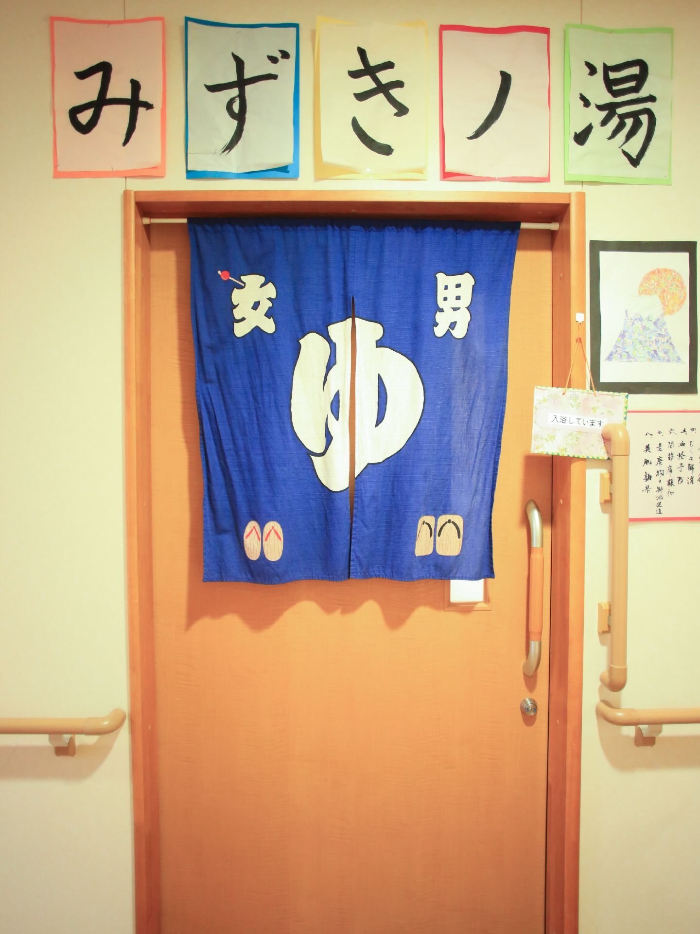 浴室の入口のドアの外には暖簾がかかっており、上に手作りの案内表示がありみずきノ湯と大きく書かれている。