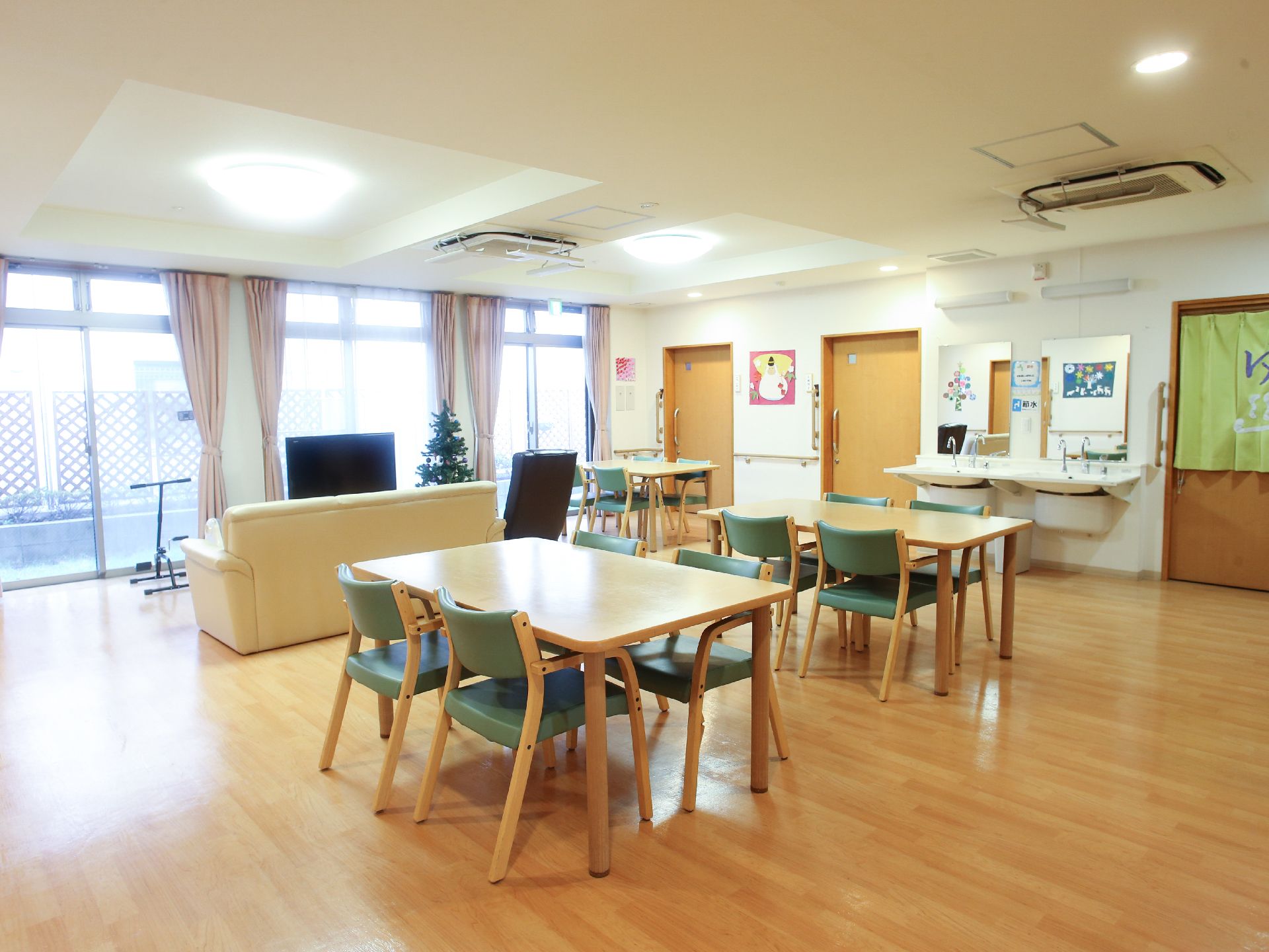 余裕を持って家具が配置された広い部屋にはテーブルセットやソファ、テレビなどが用意され、入居者様に寛いでいただけるようになっている。