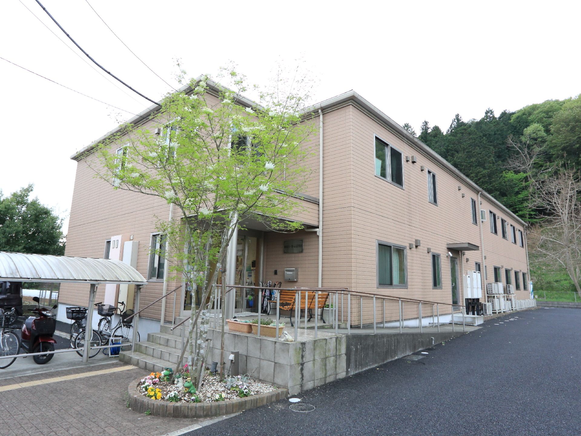 2階建てで斜面に面している。駐車場と駐輪場が隣接している。入り口は少し高い所にあり、数段の階段とスロープがどちらも用意されている。