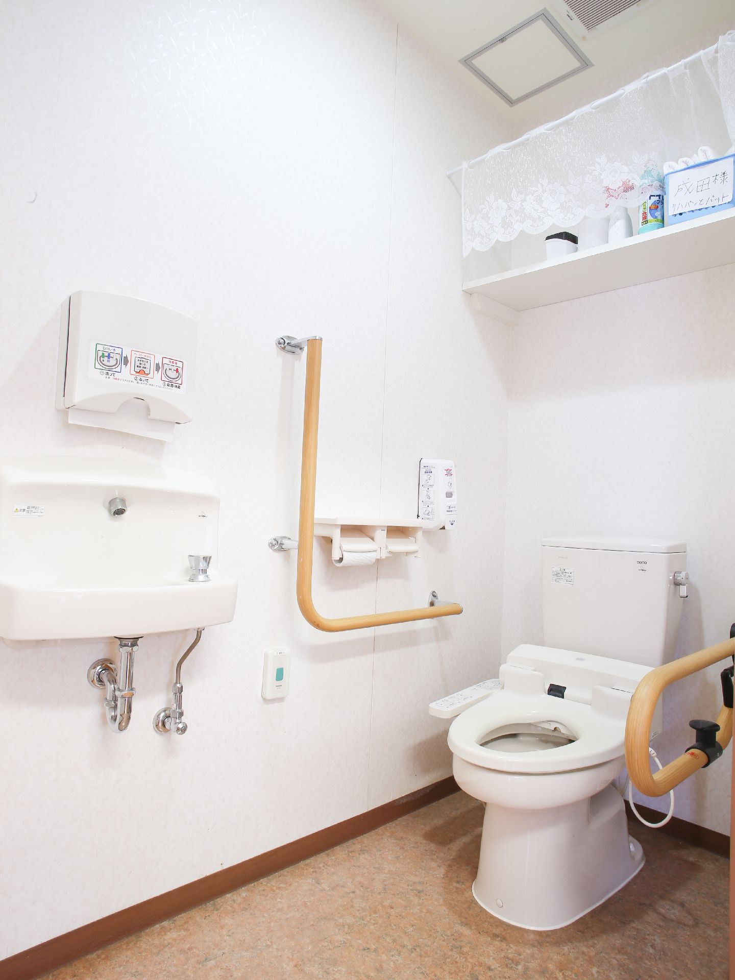 トイレの両側に手すりがついていて、楽に立ったり座ったりすることができる。水道の上にはハンドペーパーが備え付けられている。