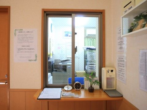 「愛の家グループホーム 練馬早宮」受付。小窓の奥はスタッフルームになっている。受付の周囲には様々なお知らせを掲示している。