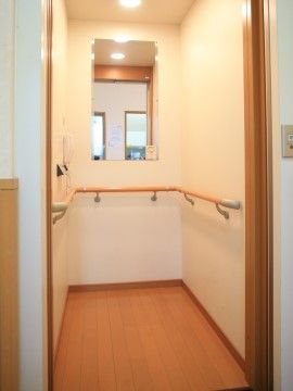 「愛の家グループホーム 練馬早宮」エレベーター。エレベーター内の壁には手すりが設置されている。正面に鏡が設置されている。