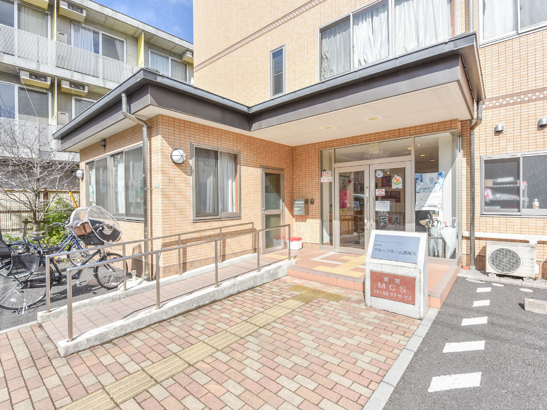 施設の出入り口にはスロープが設置されている。スロープには手すりがあり地面には展示パネルも敷設されている。