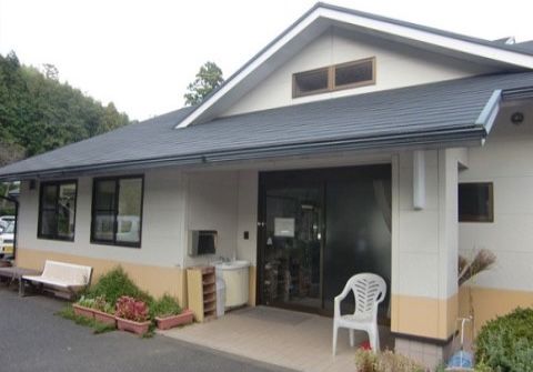 施設のまわりは山に囲まれている。出入口に白い椅子が置かれており、天気のよい日には日向ぼっこが楽しめる。