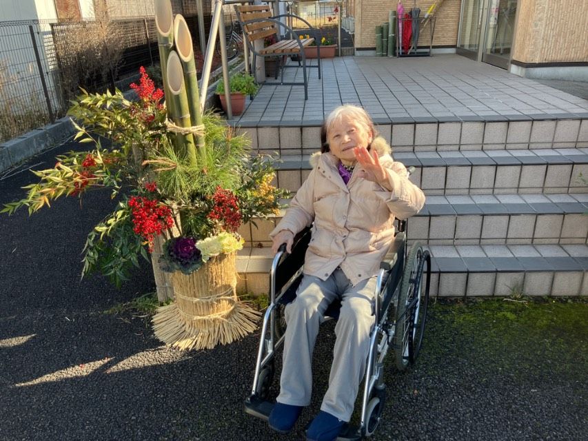 車椅子の女性と門松