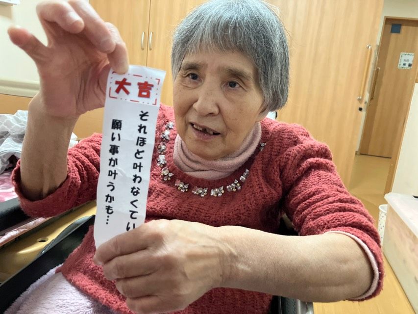 笑顔でおみくじを持つ女性
