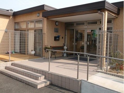 ３段の階段やスロープがあり、大きなひさしがついている施設玄関