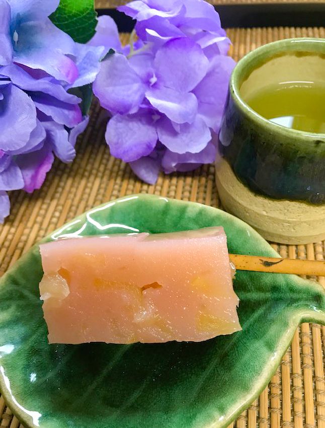紫のアジサイの花が添えられた和菓子