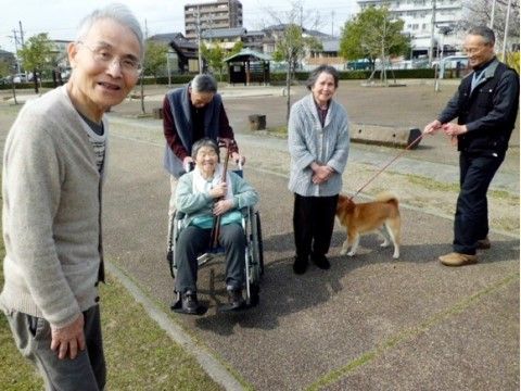 公園を散策中、犬と一緒に写真に収まっている男女の入居者様