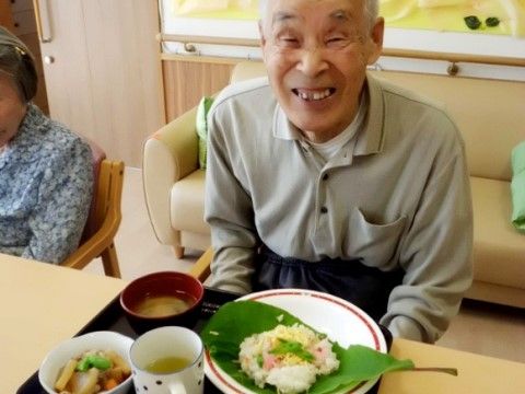 お食事のプレートを前にして、にこやかな表情を浮かべている男性入居者様