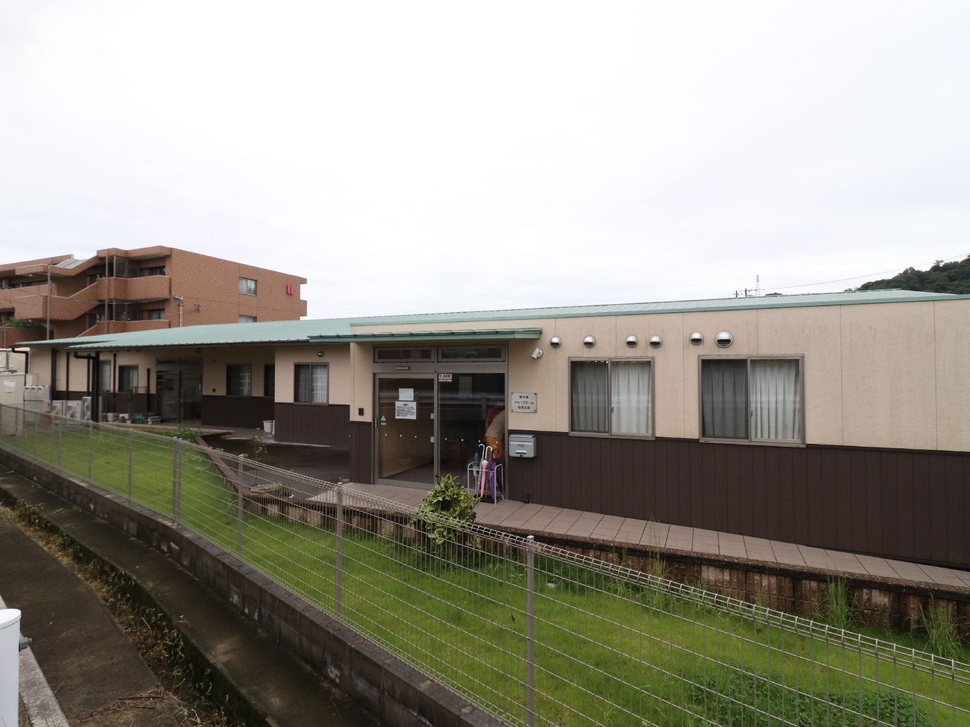 施設の建物と車道の間には十分なスペースがあり、溝とガードレールもあるので安心である。周囲に遮るものがないので、日当たりにも恵まれている。