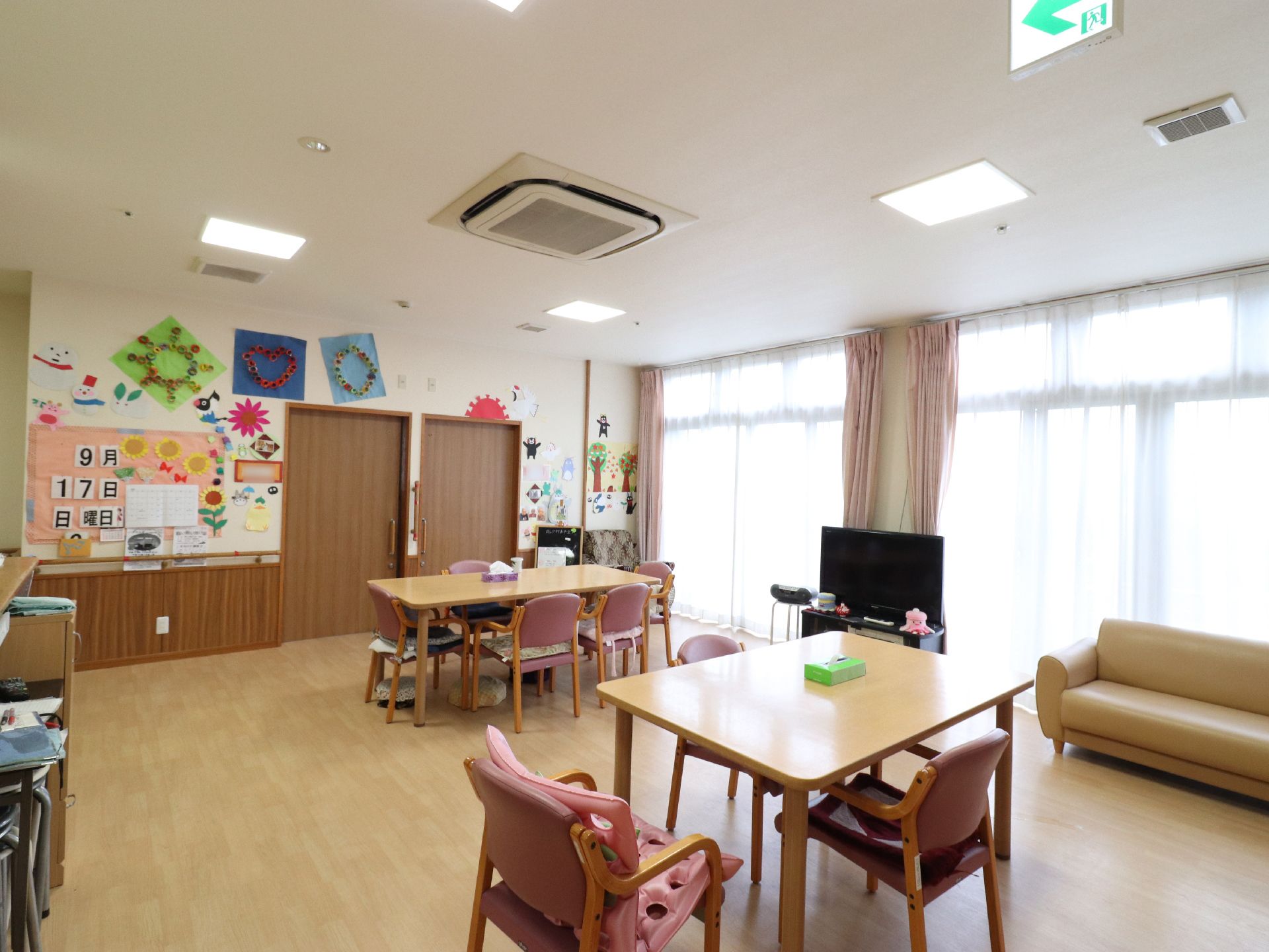 窓の多い明るいリビングルームでは、年中ご入居様同士談笑したり、テレビを観たり、レクリエーションを行って頂いたりすることができる。