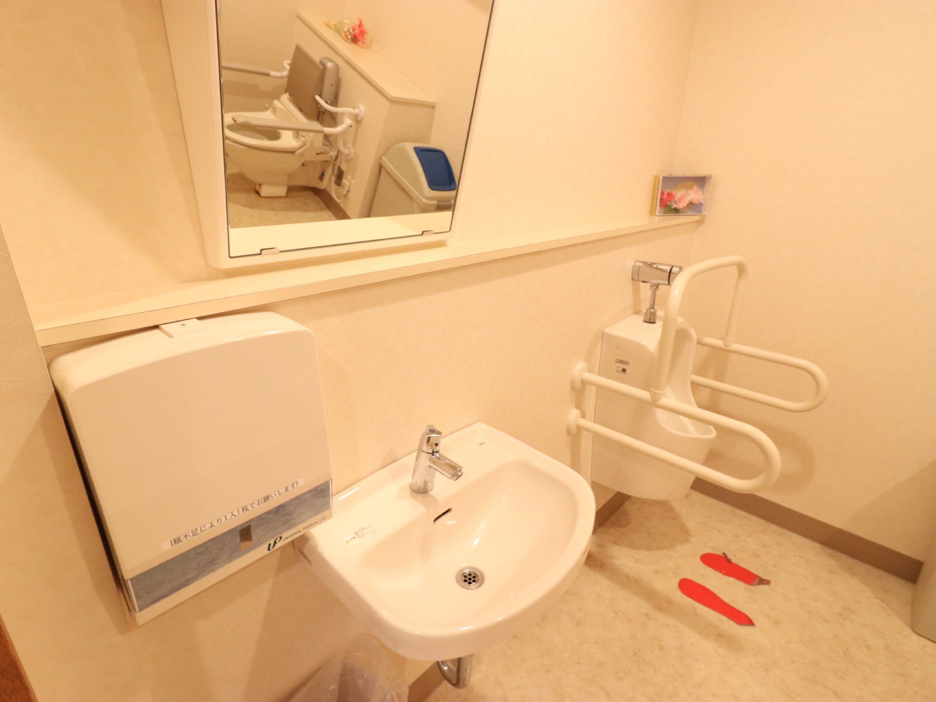 トイレスペースには手前からペーパータオルホルダー、鏡付きの洗面台、男性用便座が備わっている。常に清潔に保たれているので快適である。