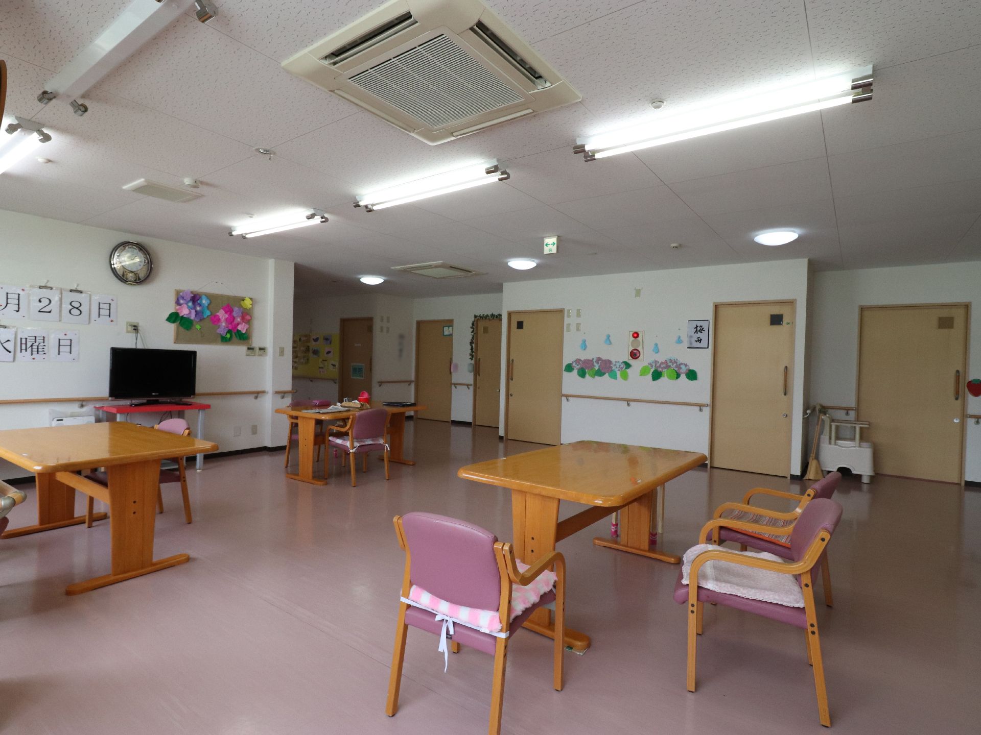 多目的ホールにはテレビが設置されている。壁には入居者が作った作品や、今日の日付が大きくプリントされて貼ってある。