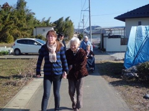 女性スタッフと手をつないで近所を散策する女性入居者様